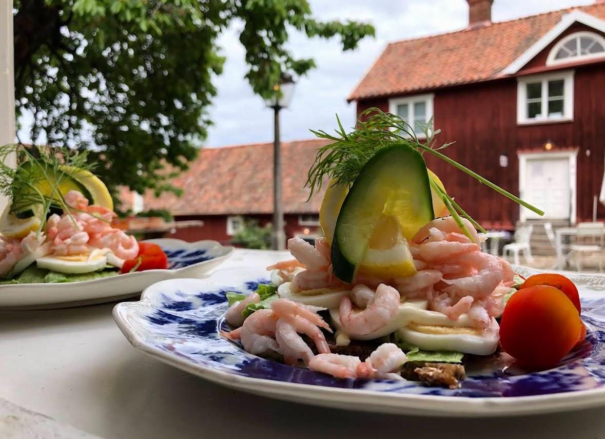 Mat serverad på caféet med Hallska Gårdens gård i bakgrunden